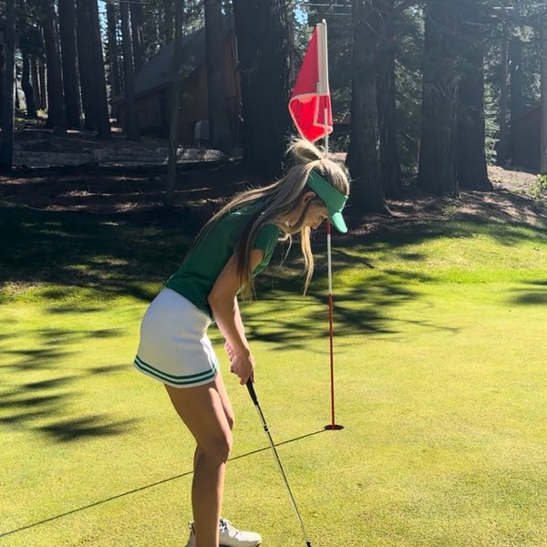 Member putting on a tree-lined green