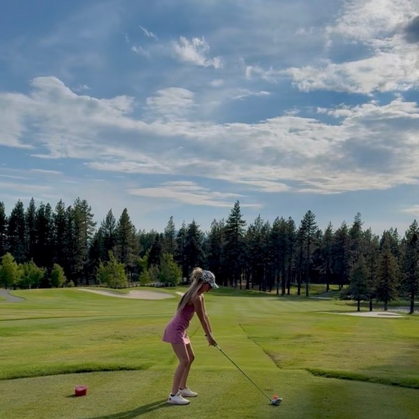 Member teeing off on the fairway under blue skies